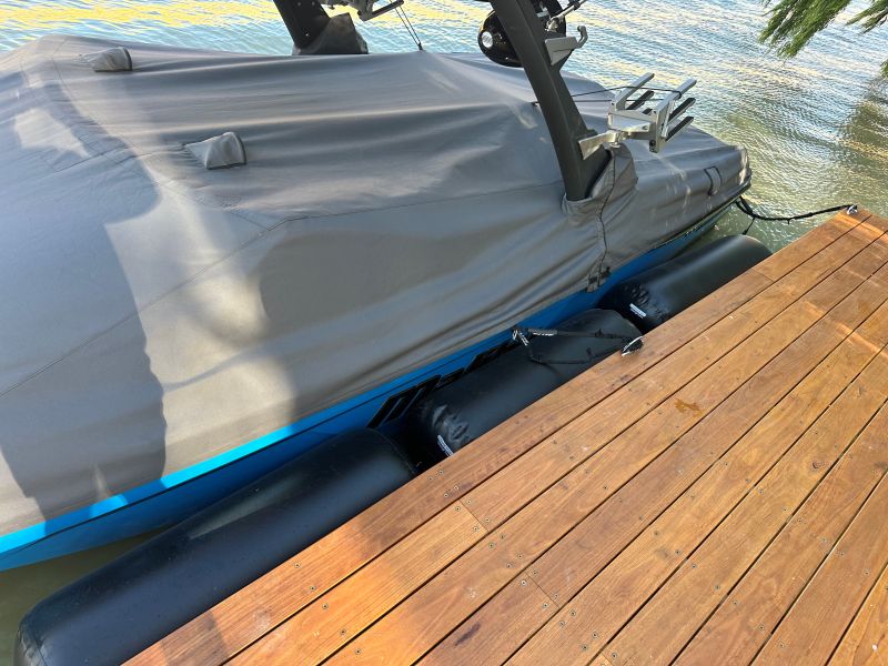 Customer photo of Hauraki inflatable fenders, fender covers and other inflatable marine products in use overed boat on a wooden dock by water